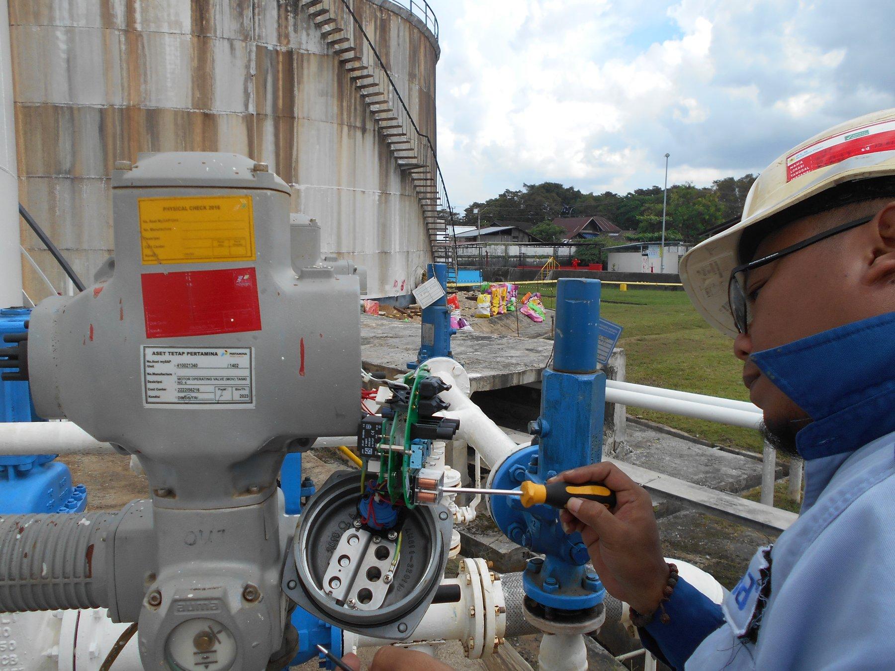 Teknisi TSI melakukan wiring pada MOV AUMA di area tangki timbun Fuel Terminal Samarinda